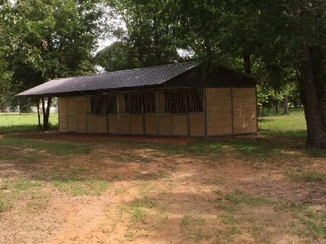 Lonestar Custom Barns Tongue and Groove Shedrow Barn. 12' x 12' stalls, 12' x 12' tack room.